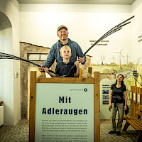 Eine Familie mit Kind besucht die Dauerausstellung Neschwitzer Vogelschutzpavillon das Vogelarten und ihre Lebensräume in Mitteleuropa präsentiert_Seeadlerflugsimulator